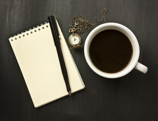 Black coffee, chain watch, notepad, ink pen, on black background