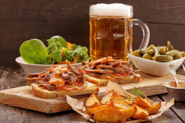 Sandwich with shredded pork, roasted potatoes and salad