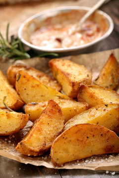 Roasted potatoes with dip on wooden table