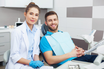 Obraz premium Portrait of a female dentist and young man in a dentist office.