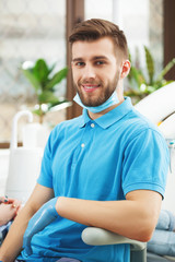 Portrait of young happy dentinst at dentist office.