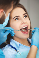 Young woman getting her teeth checked by a dentist.