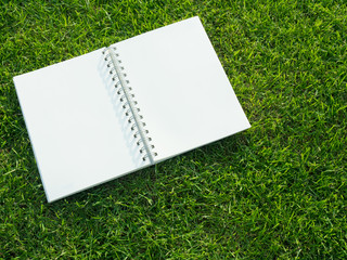 Blank notebook on grass.
