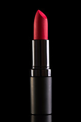 Red lipstick isolated on black background