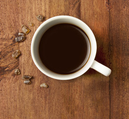 Cup of black coffee in white cup, with cane sugar