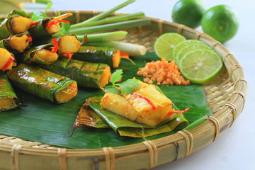 Vietnamese steamed rice pancake with shrimp on tray with banana leaf
