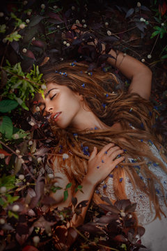beautiful girl lying on the grass with flowers
