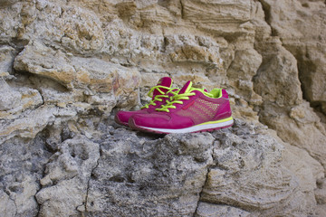 pair of pink trendy shoes on the rock mountain and rocky coast background, Lifestyle sports concept