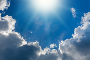 Fototapeta premium Shining sun on background of blue sky and white clouds
