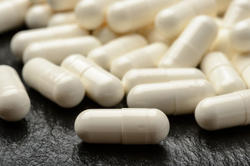 White pills on black background.