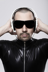 Obraz premium Portrait of futuristic man listening to music with headphones over white background