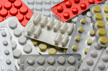 Different pills blisters as background.