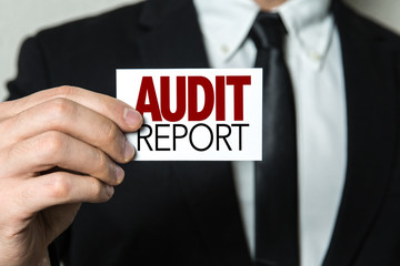 Business man holding a card with the text: Audit Report