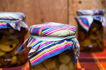 Jars with pickled mushrooms on wooden background