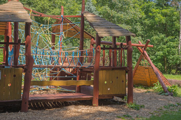 Fototapeta na wymiar Modern children playground in park, wooden playground