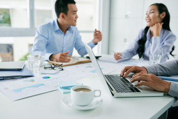 Obraz premium Young Asian business people discussing financial report