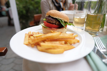 Hamburger and fries at restaurant table