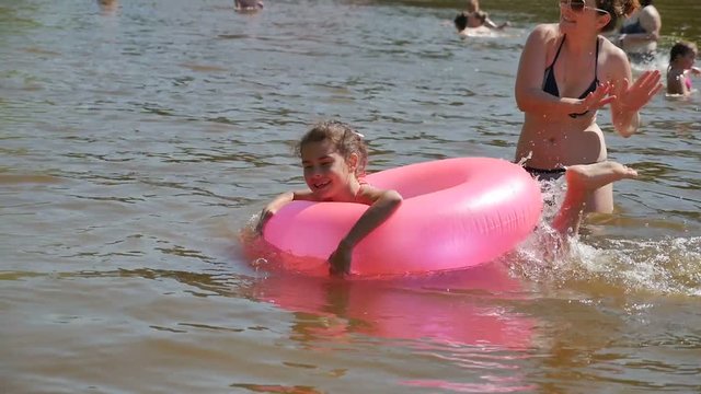 teen girl and mother floating rubber relaxation disc river vacation summer slow motion video