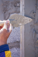 plasterer concrete worker at wall of house construction