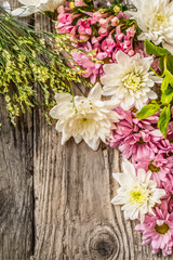 Different flowers on the wooden background vertical
