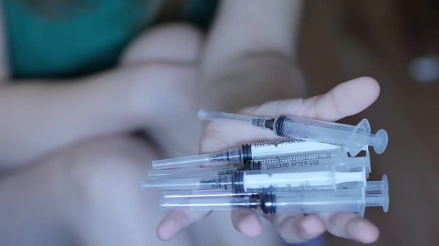 People, woman, drug addiction. Closeup of a hand with s syringe, 4K UHD.