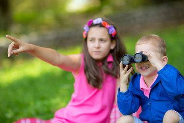Obraz premium Boy and girl exploring the environment with a binocular