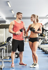 Fototapeta na wymiar smiling man and woman talking in gym