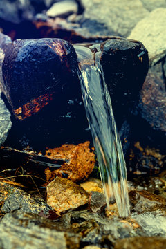 Water flowing out of a wooden trough, blue dominanta picture