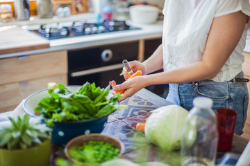 Woman cooking in kitchen with ingredients around her