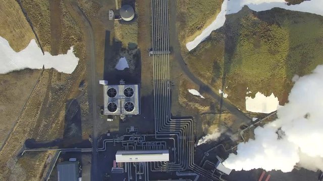 Aerial view of a geothermal power plant in Iceland. Steam rising upp against the sunlit sky from the plant