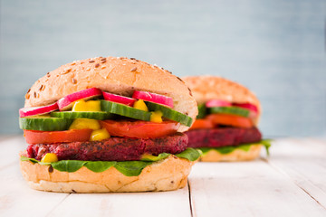 Veggie beet burger on white wooden and blue background

