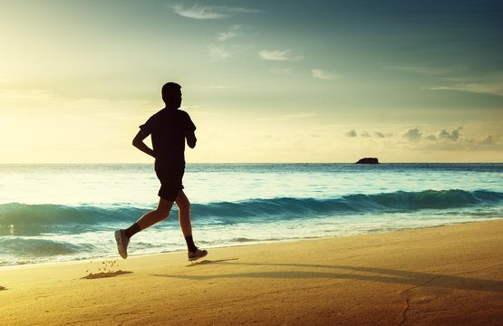 Man Running On Tropical Beach At Sunset