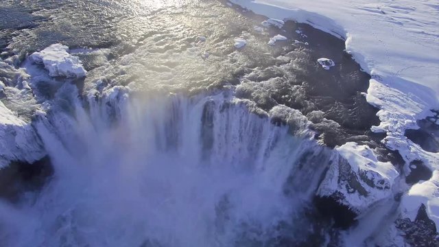 Aerial ultra high definition video of Godafoss waterfall in Iceland. Footage shot in winter with snow on the ground. Shoot with a DJI phantom pro. Drone travels downriver and over the waterfall itself