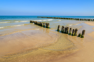 Wooden breakwater on beach in Ustka town, Baltic Sea, Poland