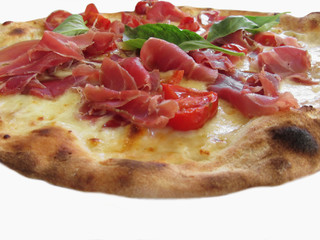 Original italian pizza with ham, tomatoes and fresh basil isolated on white background