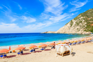 Row of umbrellas with sunbeds on Petani beach, Kefalonia island, Greece