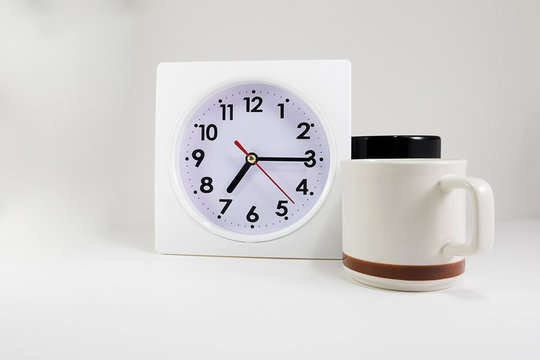 clock with two coffee cup on isolated background