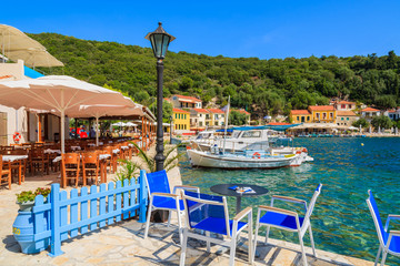 Chairs and tables in local restaurant in Kioni port, Ithaka island, Greece - obrazy, fototapety, plakaty