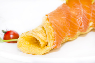 scrambled eggs with cheese and salmon decorated with tomato on white background
