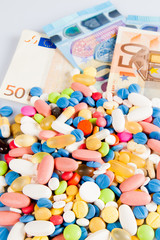 Pills of different colors on money