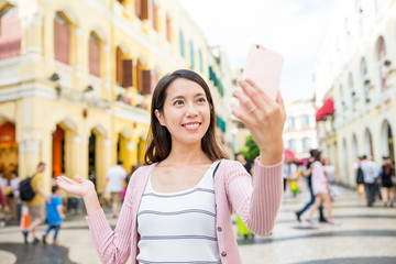 Woman use of mobile phone to take photo in Macao