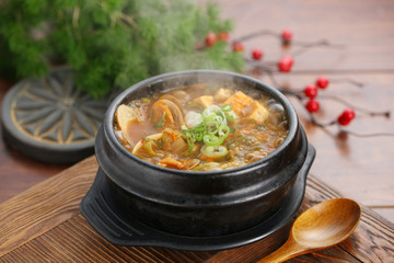 Chinese clams soup in black bowl on the table in restaurant