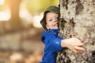 Young boy hugging a tree