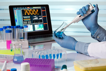 chemical engineer working in laboratory with pipette and flask / scientist holding flask and...