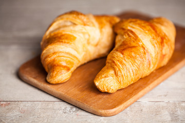Fresh baked croissants on wooden table