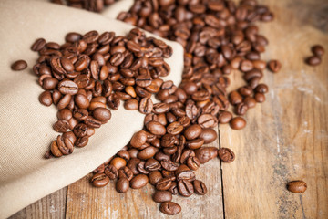 Coffee beans on wood background. Selective focus.