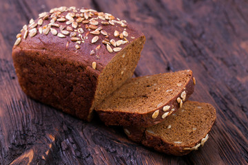 Rye bread with sunflower seeds on an old wooden table