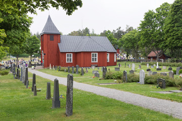 Obraz premium Traditional old wooden red church and a graveyard