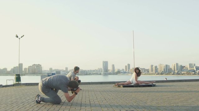 Sport sexy girl model does the splits on nature for two photographer