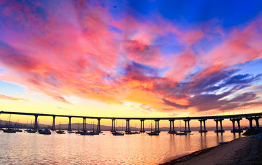 Fototapeta na wymiar Coronado Island vibrant cloudy sunrise over Coronado Bridge and San Diego Bay. San Diego, California USA.